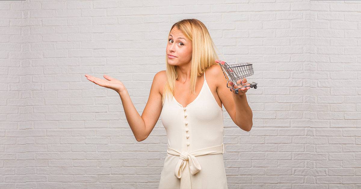 Young-blonde-woman-holding-a-tiny-ecommerce-shopping-trolley-asking-herself-if-shopify-is-worth-it