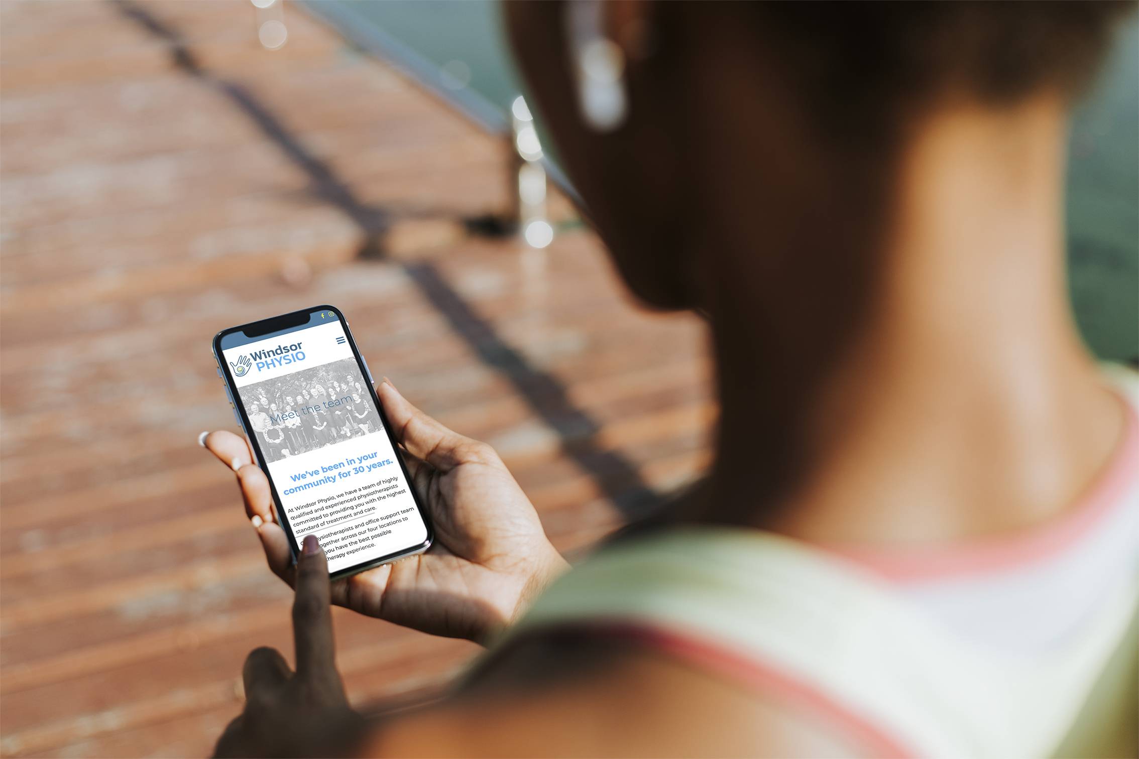 Image Looking Over A Person'S Shoulder Looking At Client'S Website On A Mobile Phone